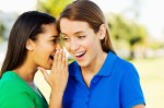 teenage girl Sharing Secret With Friend In Park
